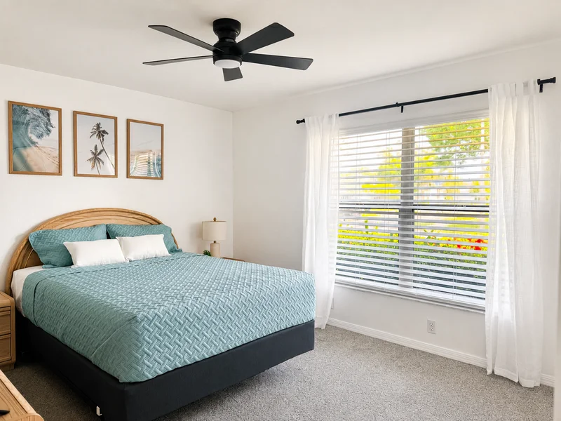 Second bedroom with teal bedding and a bright window