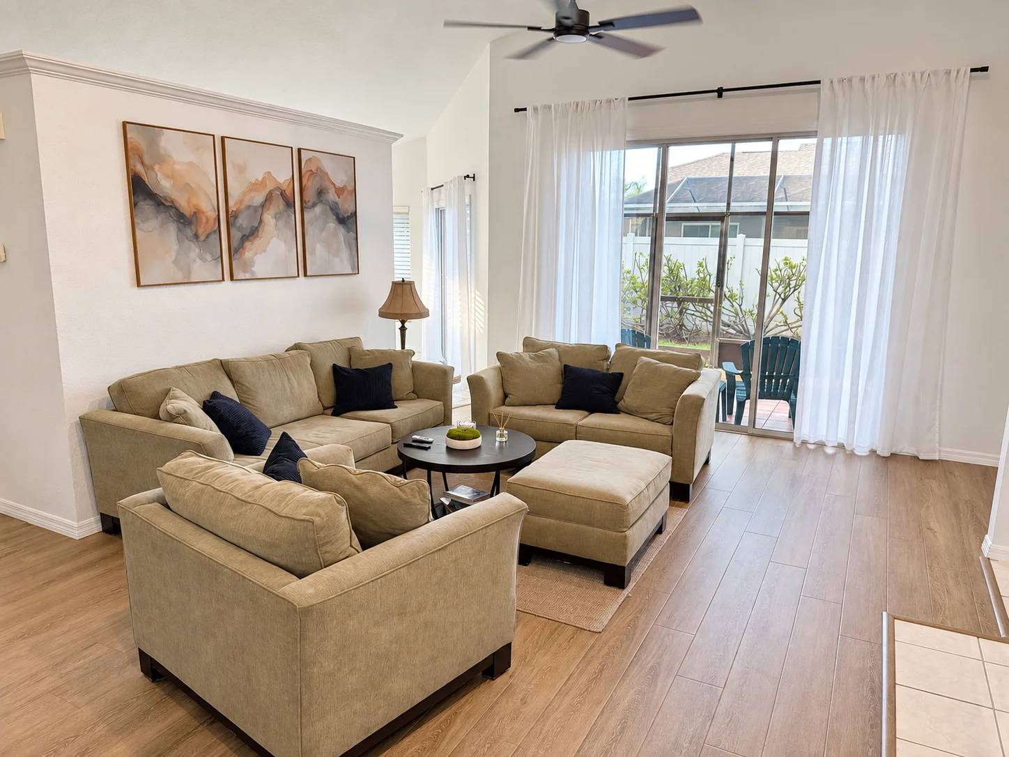Bright NestPoint living room with beige seating and sliding doors to the screened porch